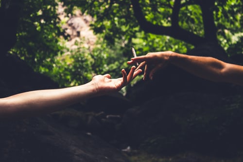 A person handing over a joint to another