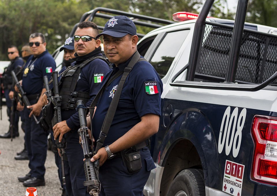 Members of Mexico’s Policia Federal standing in front of a truck carrying rifles