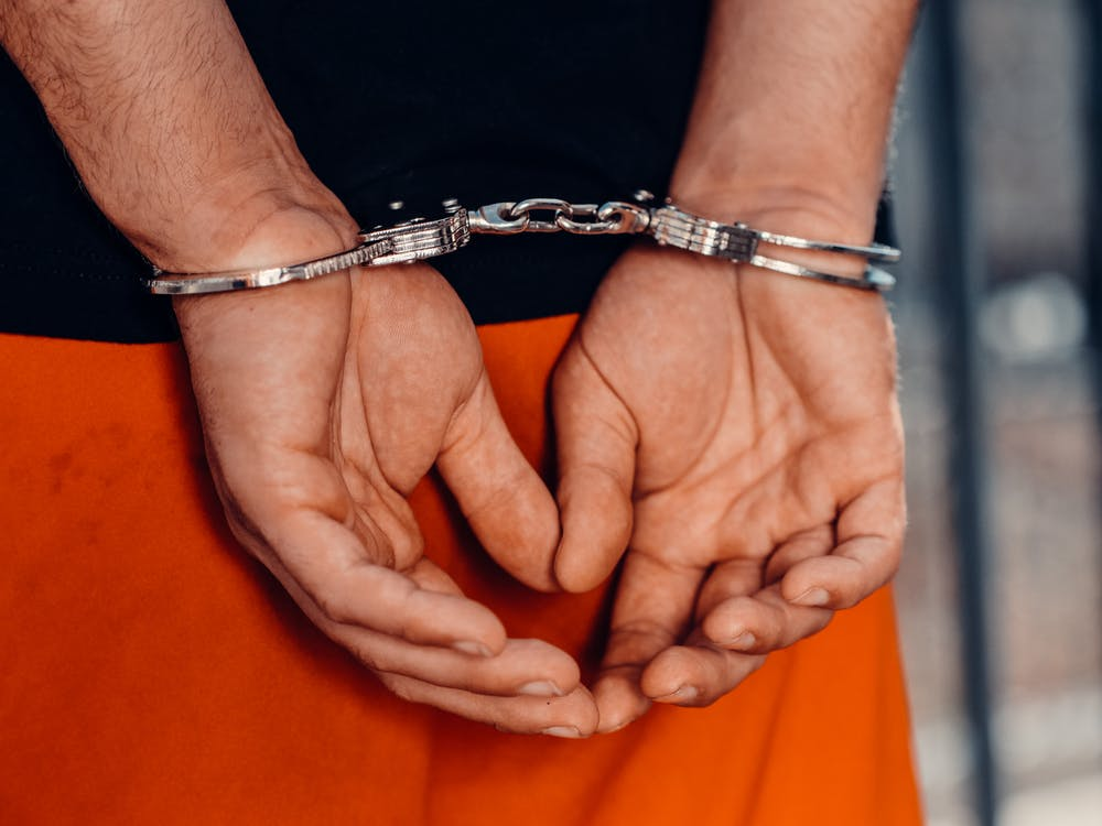 A person wearing handcuffs with their hands behind their back