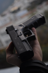 A person holding a Glock pistol in their hand