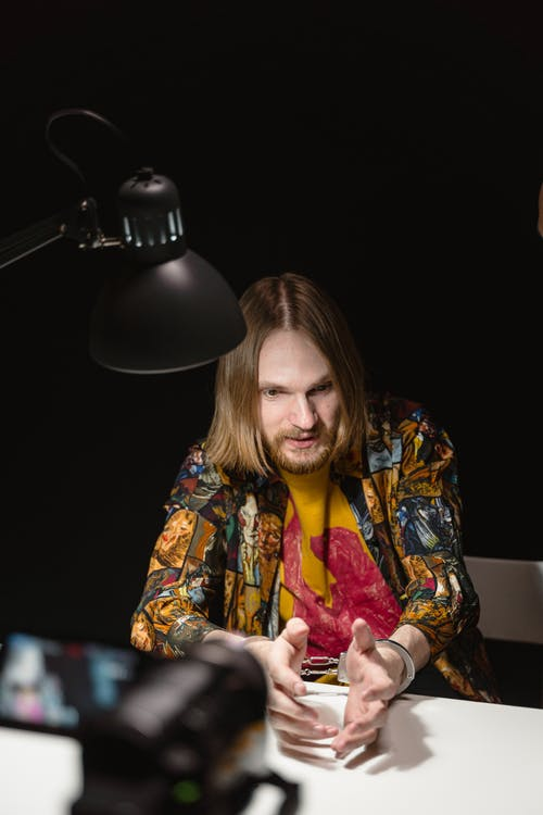 A man being filmed talking in an interrogation room