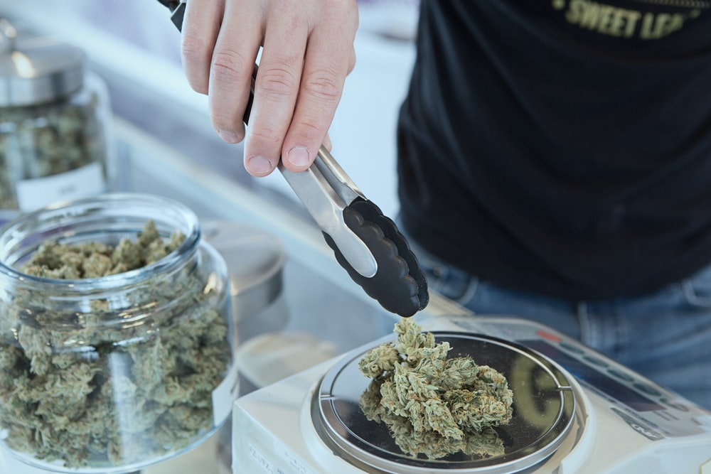 A man taking out cannabis from a jar