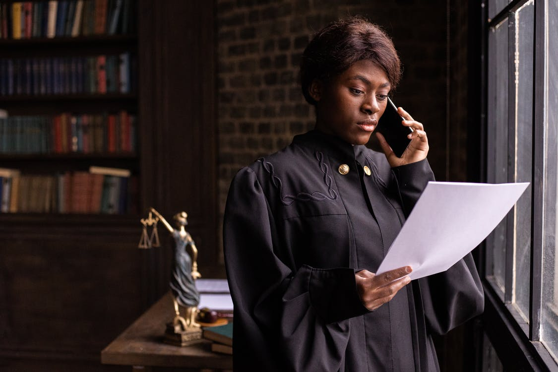 A judge holding a document while speaking on the phone
