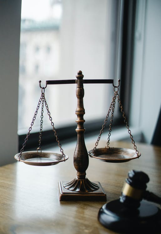 A scale and a gavel on a desk