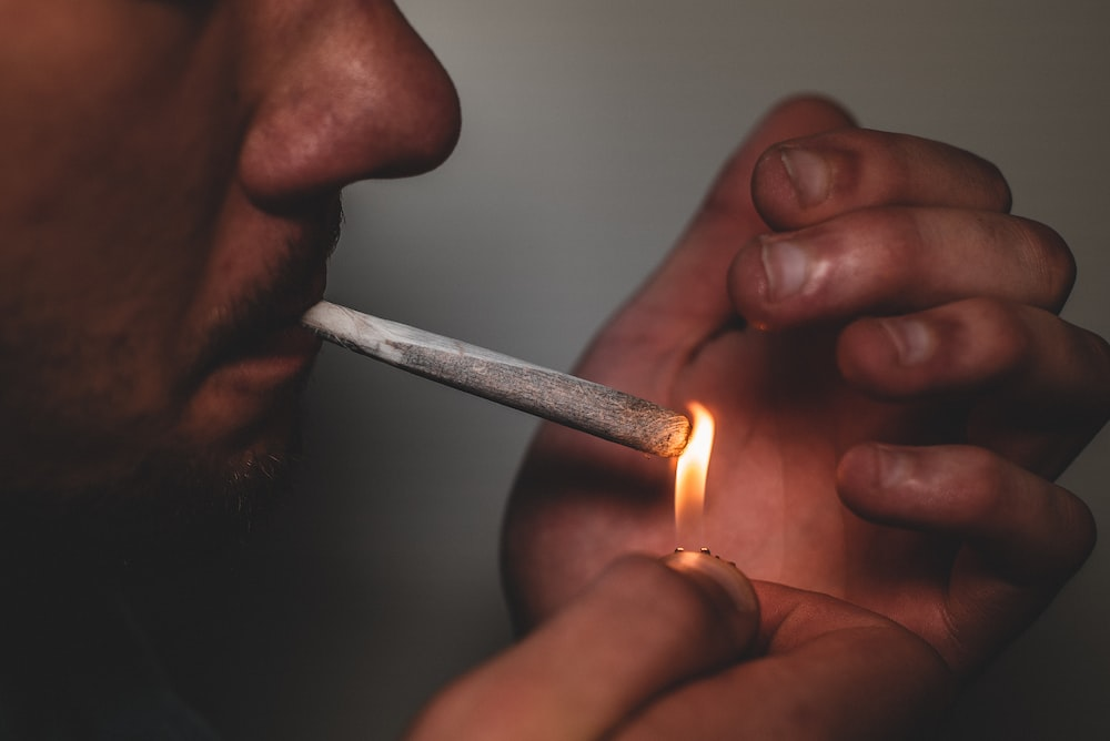 A person lighting a cannabis joint